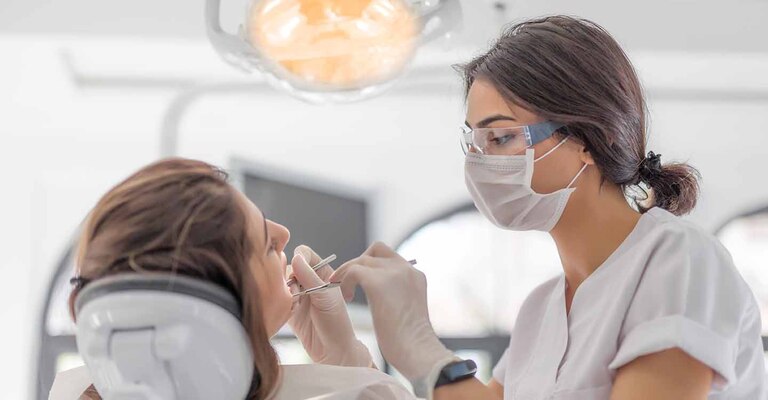Eine Patientin wird mit einer professionelle Zahnreinigung behandelt